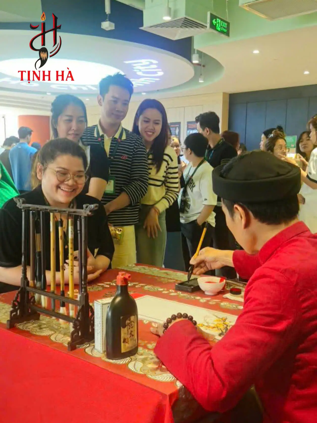Ông đồ viết thư pháp bên giấy đỏ và mực tàu trong không gian Tết truyền thống