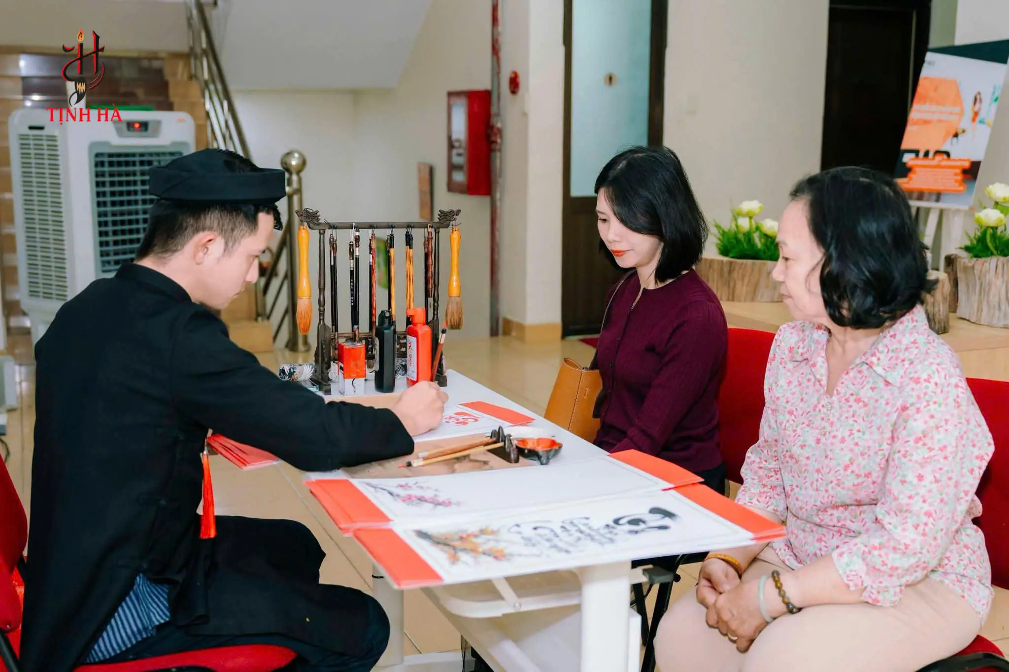 Khách trải nghiệm xem ông đồ viết thư pháp trực tiếp tại sự kiện