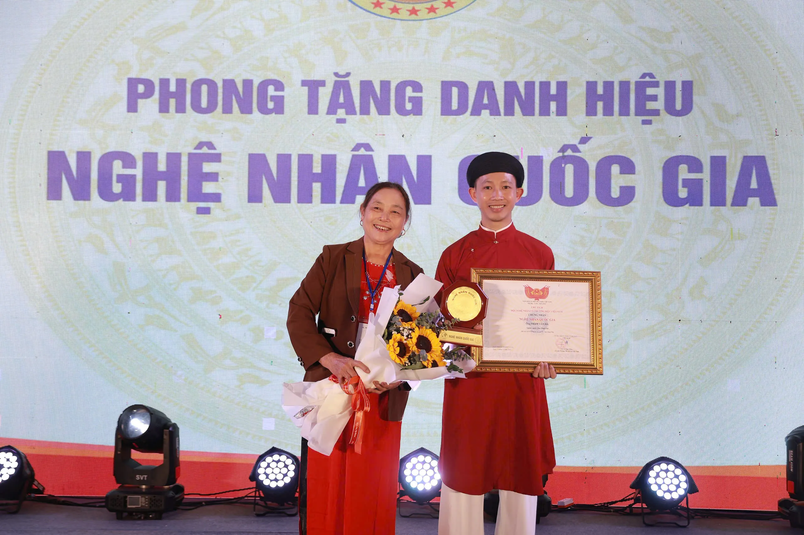 Nghệ nhân Phạm Văn Hà chụp ảnh cùng mẹ tại lễ phong tặng danh hiệu Nghệ nhân Quốc gia