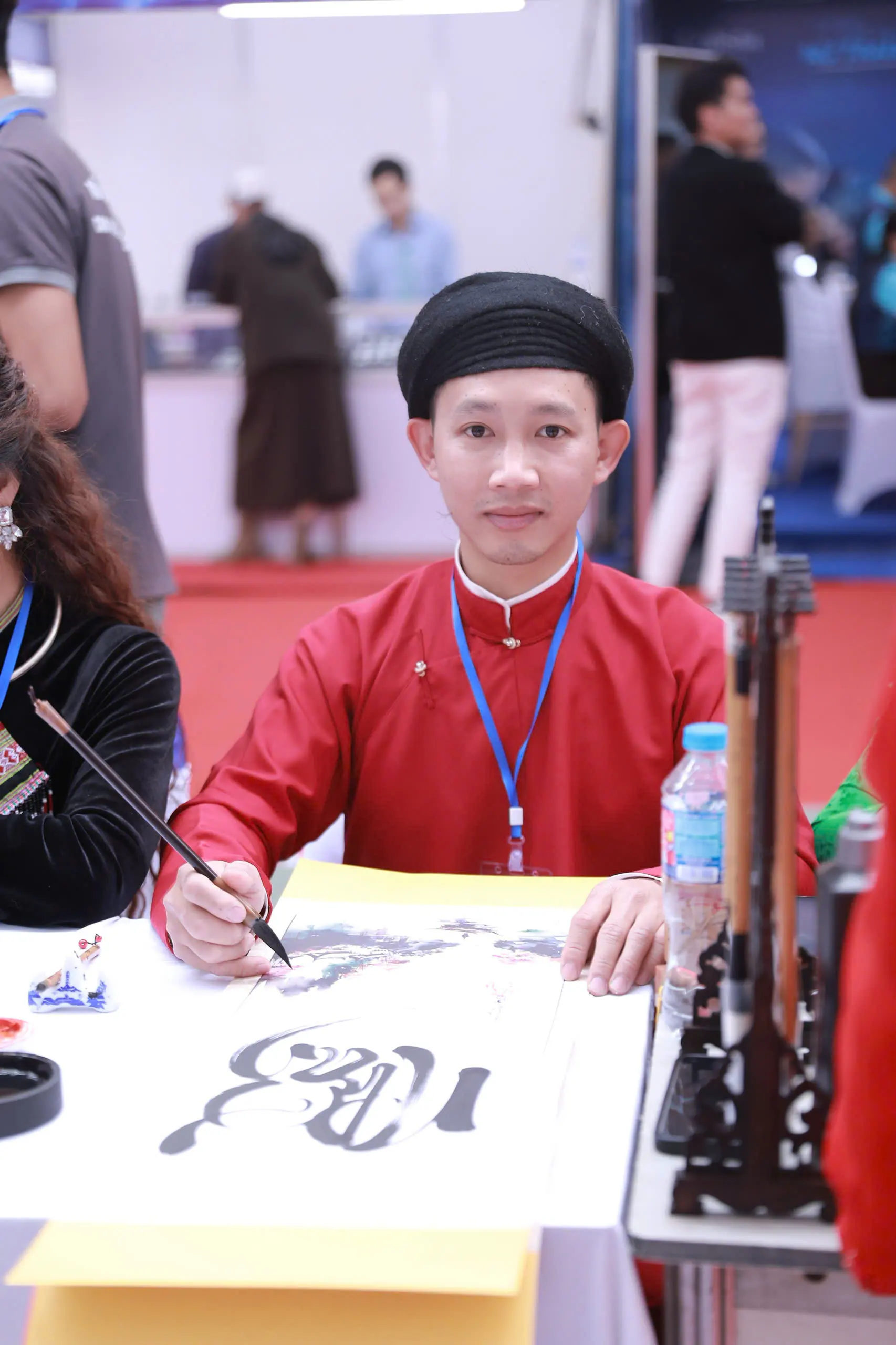 Nghệ nhân Phạm Văn Hà đang viết thư pháp Việt tại sự kiện văn hóa