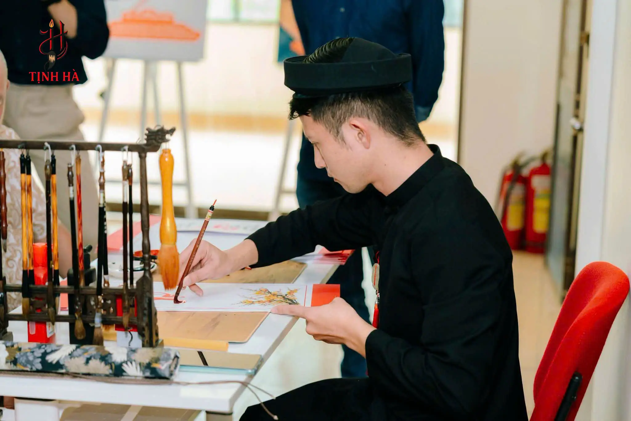 Nghệ nhân viết thư pháp bên bộ bút lông tại sự kiện FWD