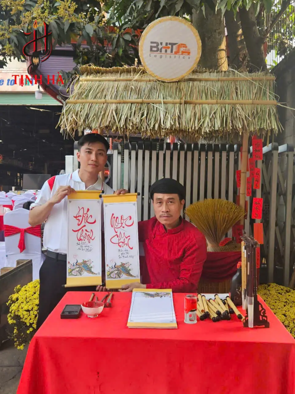 Ông đồ viết thư pháp tên Đức Thành và Ngọc Châu tặng khách tại sự kiện BHT Group