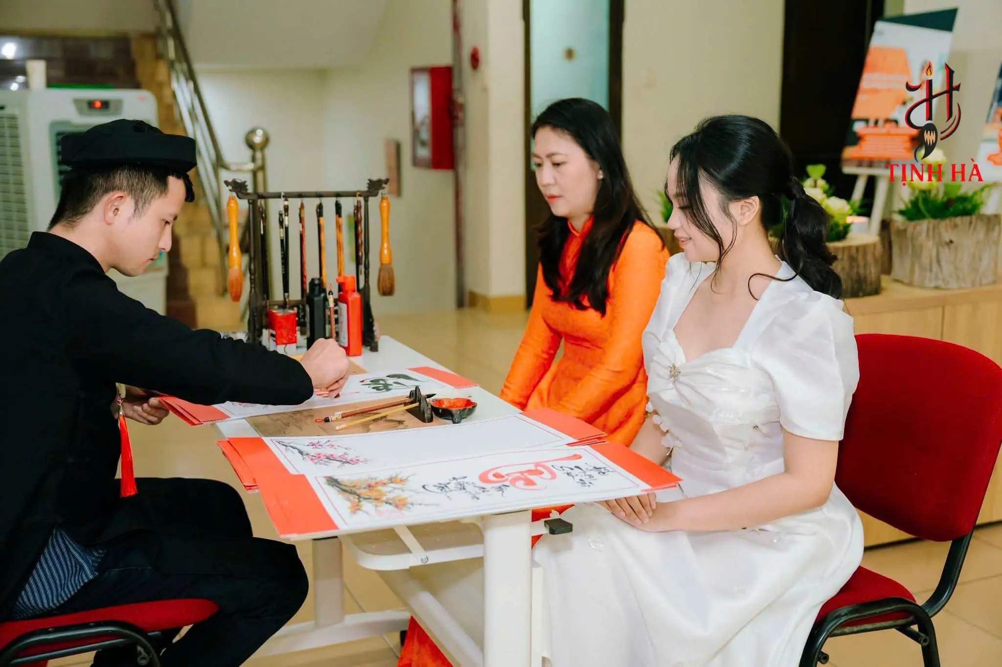 Ông đồ viết thư pháp cho khách trước giờ khai tiệc