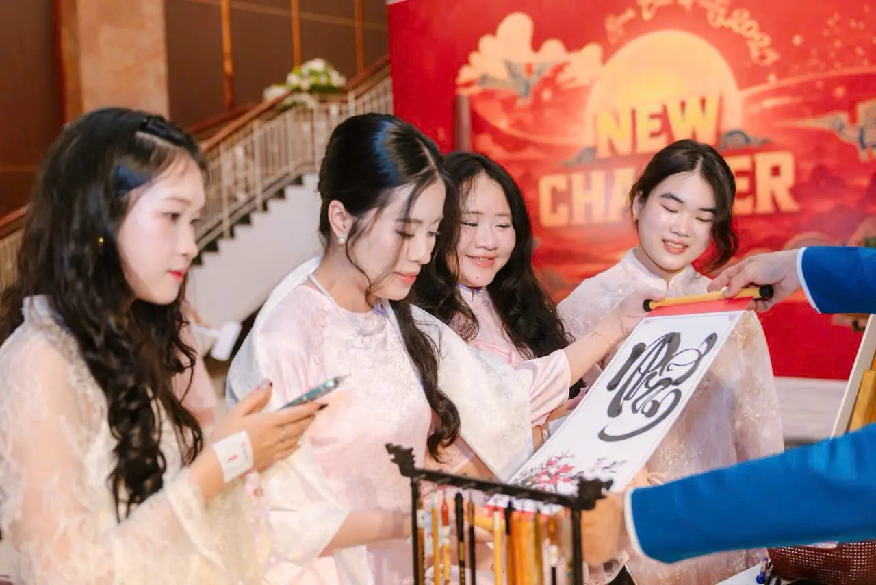Guests receiving personalized Vietnamese calligraphy during a Tet celebration.