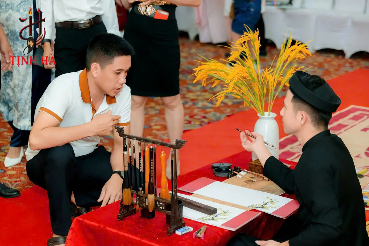 Bàn thư pháp với bút lông, mực tàu và giấy đỏ trong dịch vụ thuê ông đồ viết thư pháp tại TPHCM