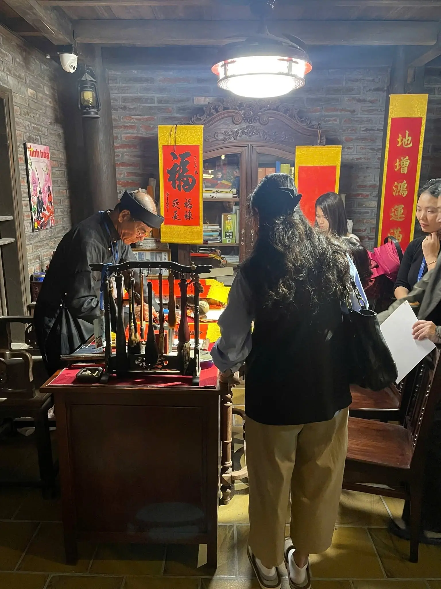 Visitors experiencing authentic Vietnamese calligraphy in a traditional cultural space.